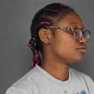 Side profile view of young woman's ear after keloid removal surgery, braided hair – Plastic Surgery of New York
