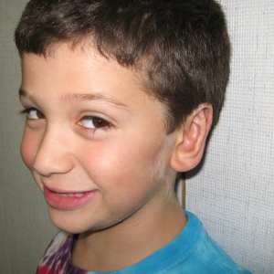 Candid smiling photo of young boy after otoplasty surgery